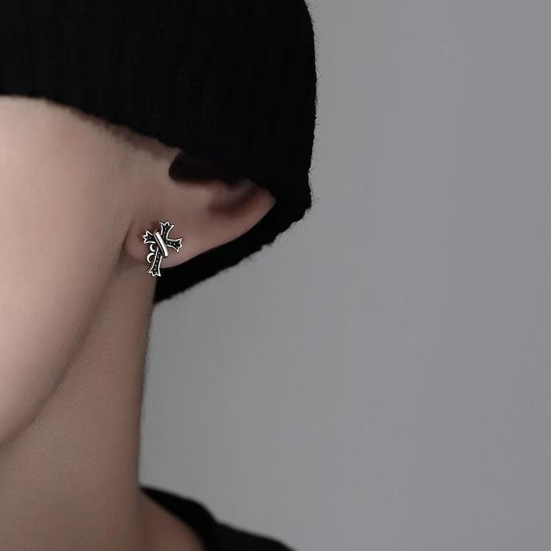 Cross stud earring worn with black clothing, artistic side profile shot