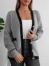 Gray knit cardigan buttoned up, showing black trim and pockets, worn with white tank and jeans