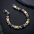 A high-contrast image of the black and gold bracelet resting on a dark surface, emphasizing its metallic finish and bold geometric links.