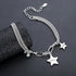 A close-up of the bracelet draped over a textured black cylindrical display, showcasing its chain-link structure, charms, and bead details.