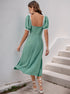 Back view of green puff sleeve dress with lace trim and fitted waist.