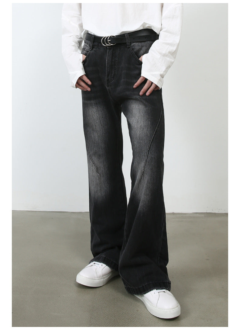 Model with hands in pockets wearing white button-up shirt, black belt and black wide-leg denim jeans with white sneakers