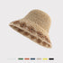 A close-up of a beige woven bucket hat with a brown floral pattern, showcasing the texture and woven details on a neutral background.