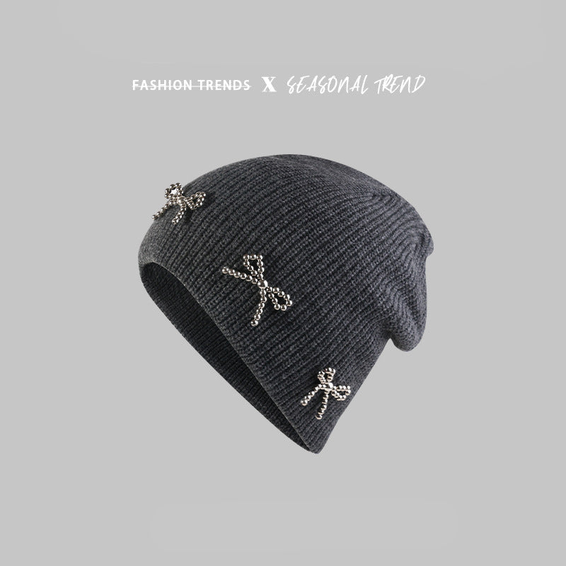 Dark gray beanie with "Peipi Hat Industry" text, featuring pearl-studded bow decorations