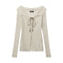 Cream ribbed knit sweater with sailor-style collar, lace-up front with beaded ties, and distressed edges. Nariele brand label visible
