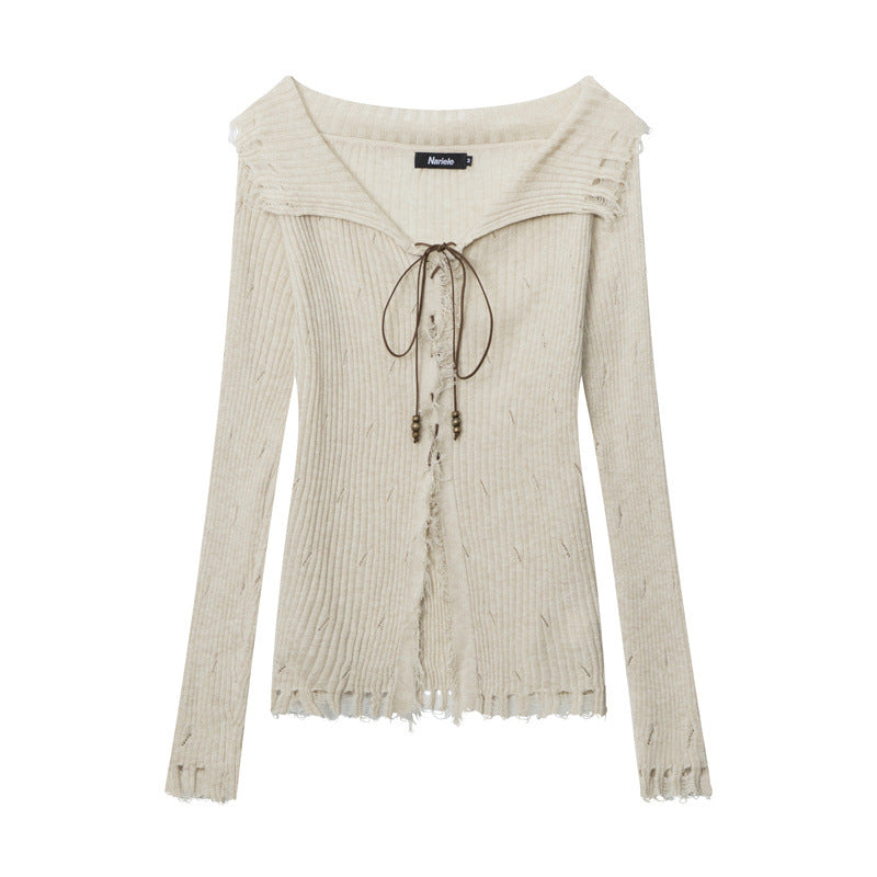 Cream ribbed knit sweater with sailor-style collar, lace-up front with beaded ties, and distressed edges. Nariele brand label visible