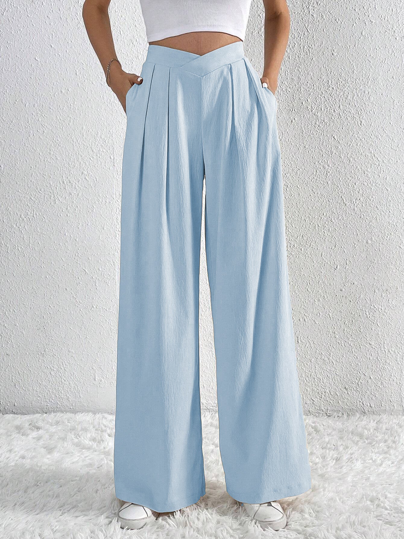 Light blue pleated wide-leg trousers with high waist and side pockets.