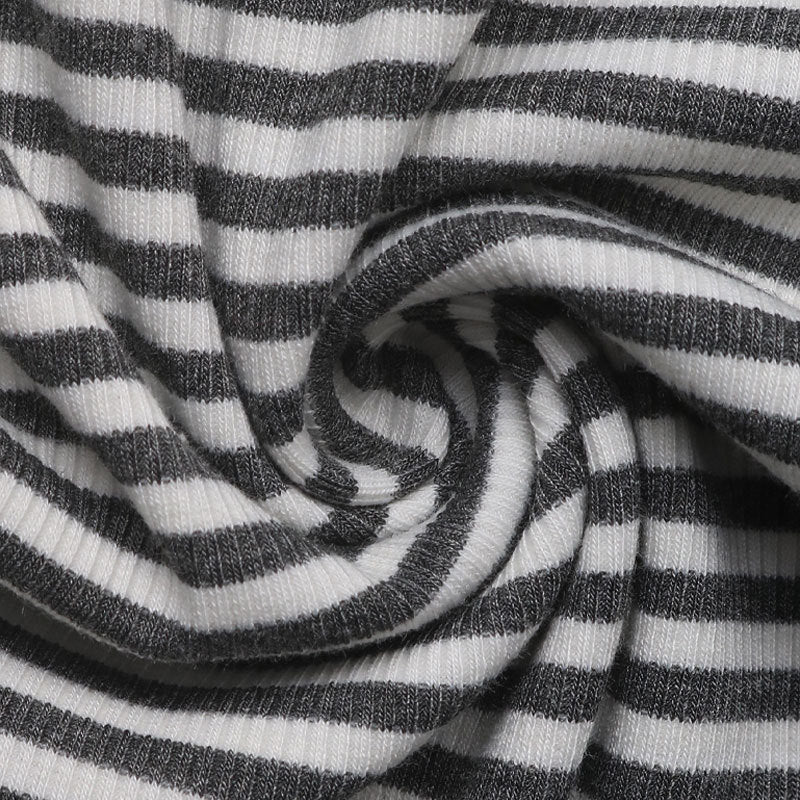 Close-up of black and white ribbed striped fabric, swirled to showcase texture and material.