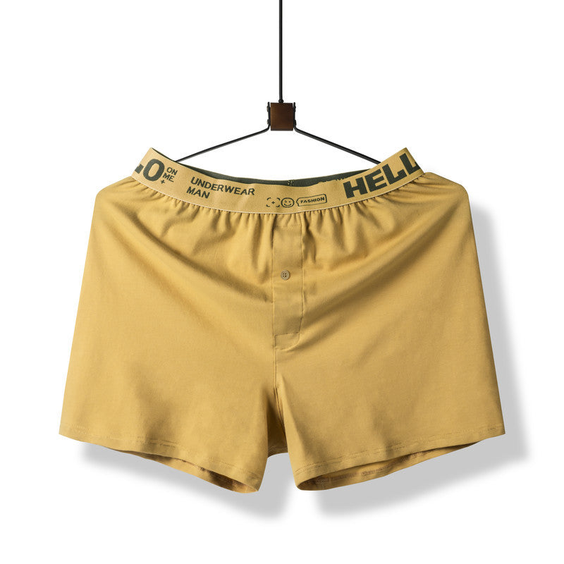 Yellow boxer short with branded elastic waistband displayed on hanger against white background