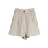 Product shot of beige linen shorts with pleated front, side pockets, and brass button closure on white background