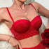 Product lifestyle photo of red sparkle bustier bra styled with roses and delicate jewelry