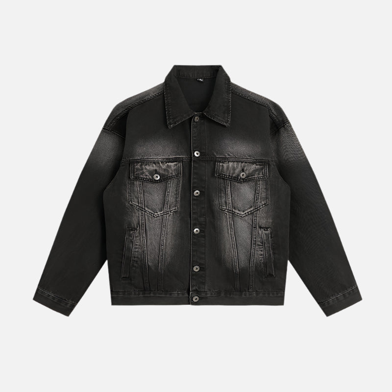 A black washed denim jacket with an ombre fade effect laid flat, highlighting its structured design