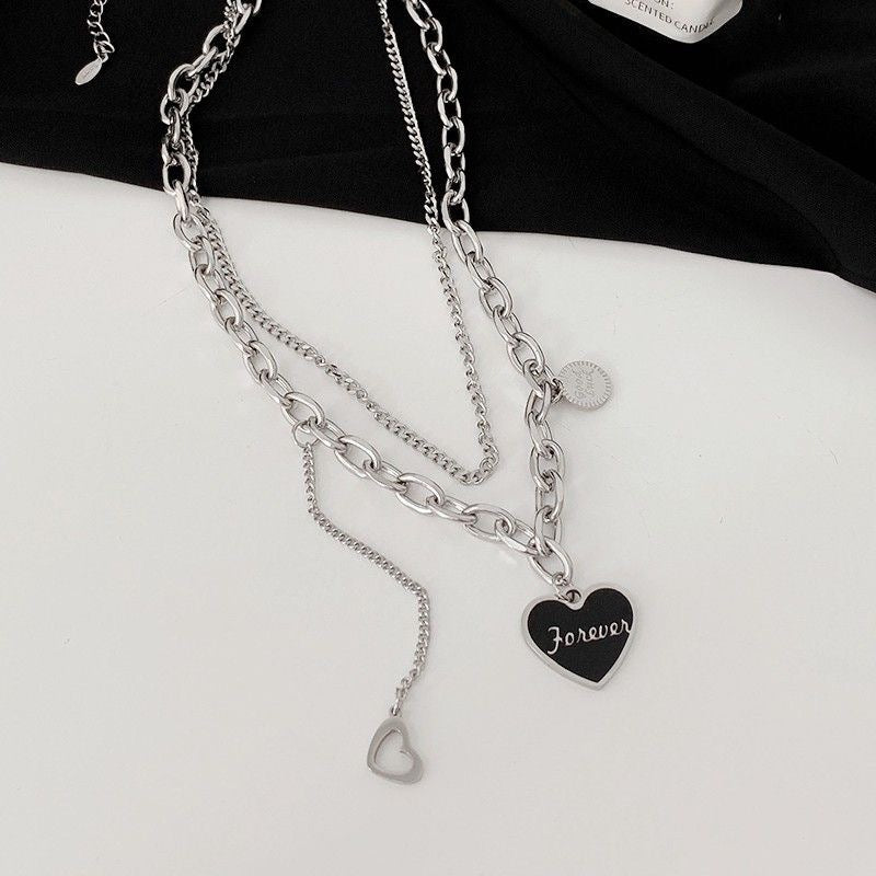 Multi-layer silver chain necklace with chunky and thin chains, black "Forever" heart pendant, and small heart charm