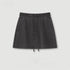 Black cotton mini skirt with drawstring waist and side seam detail displayed on white background