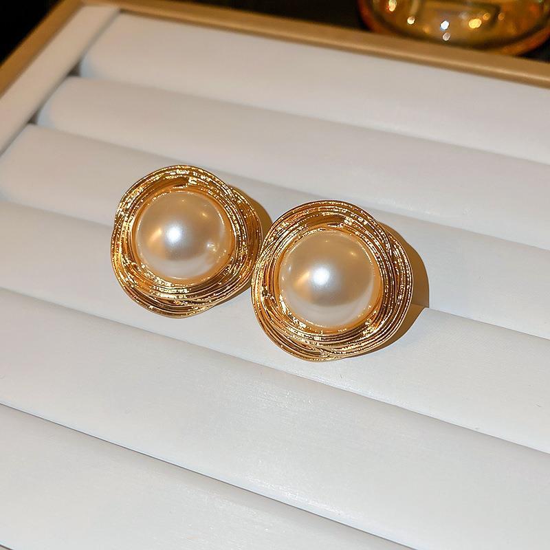 Gold and Pearl Stud Earrings – Elegant gold stud earrings featuring a central pearl encased in a textured gold frame