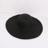 Black wide-brimmed sun hat with a structured design, laid flat against a white background.