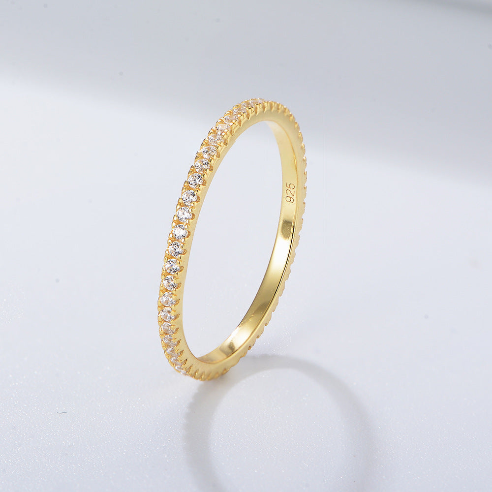 Clear zircon eternity band in 14k gold setting with classic prong design, stamped 925