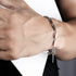 Men’s pearl and stainless steel bracelet with a sleek chain-link design, worn on wrist against a white background.