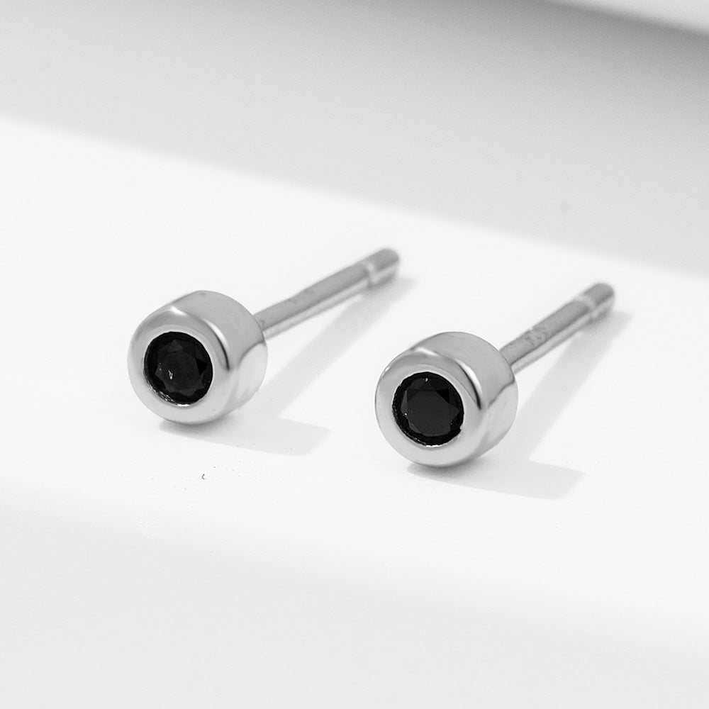 Silver version of round stud earrings with black nano zirconia stones on white background