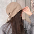 Back view of khaki knit beanie showing drawstring and texture detail