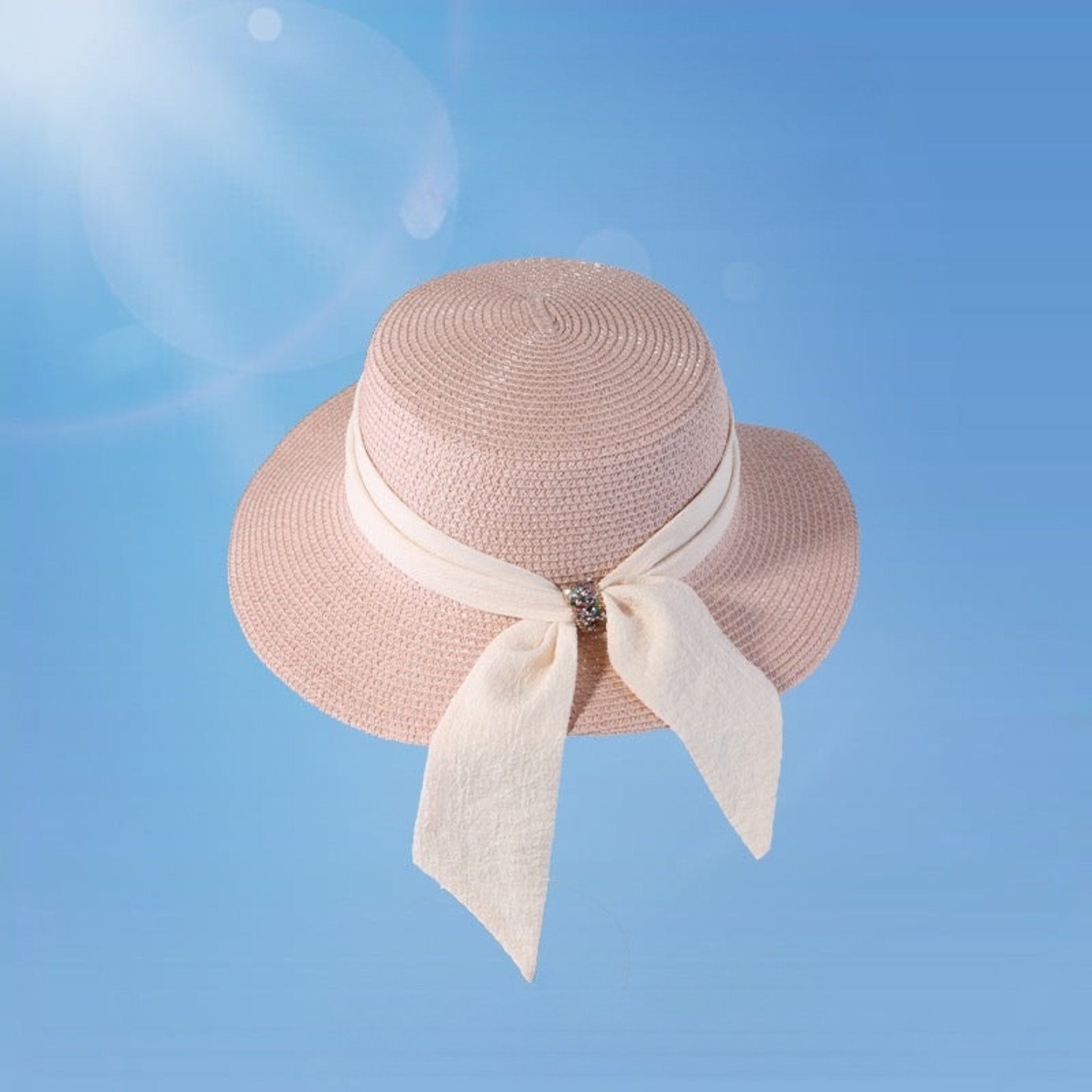 Women's elegant bowknot straw hat in soft pink with a wide brim and crystal-accented bow. Stylish sun protection for beach outings or summer strolls.