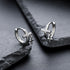Cross pendant hoops displayed on angular black stones