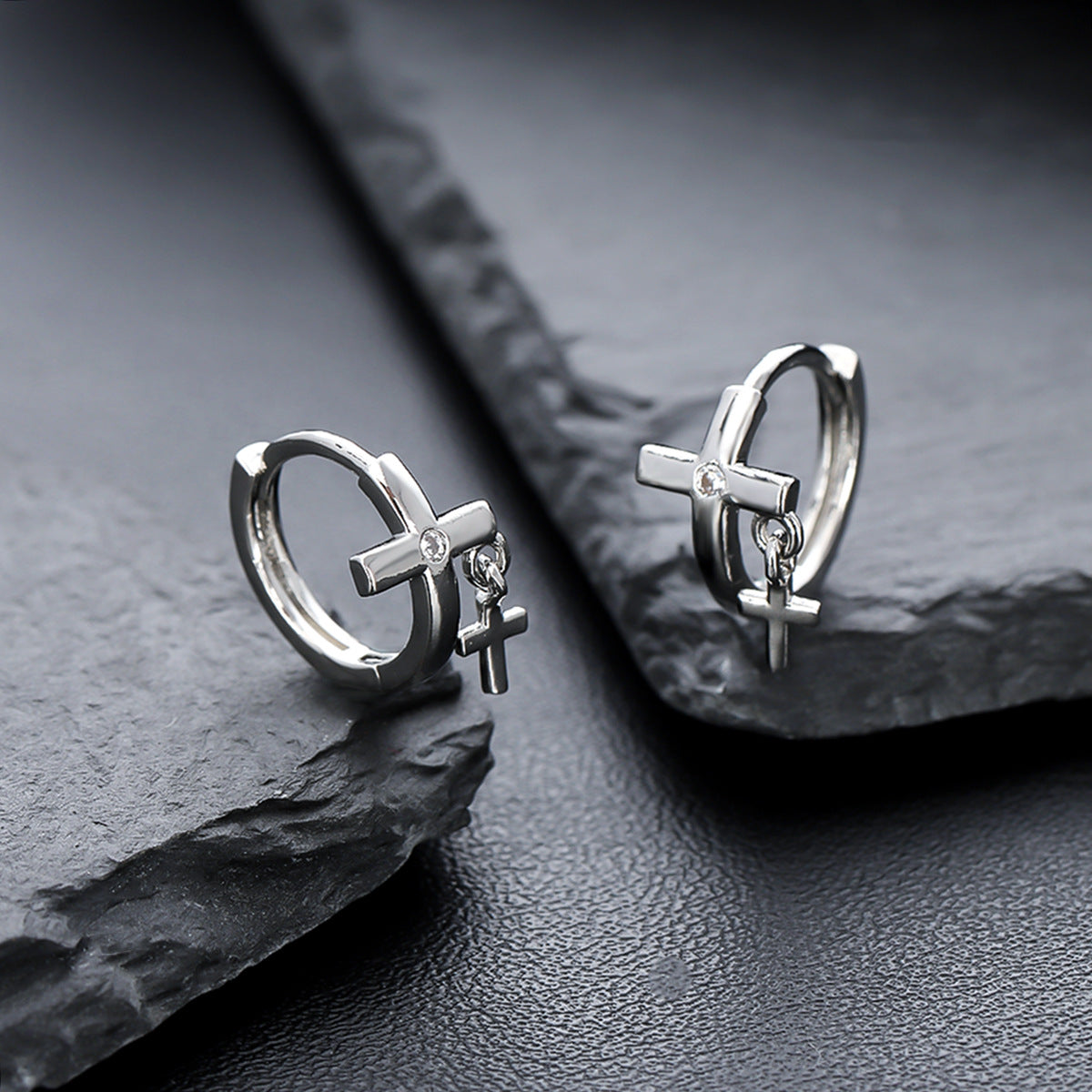 Cross pendant hoops displayed on angular black stones