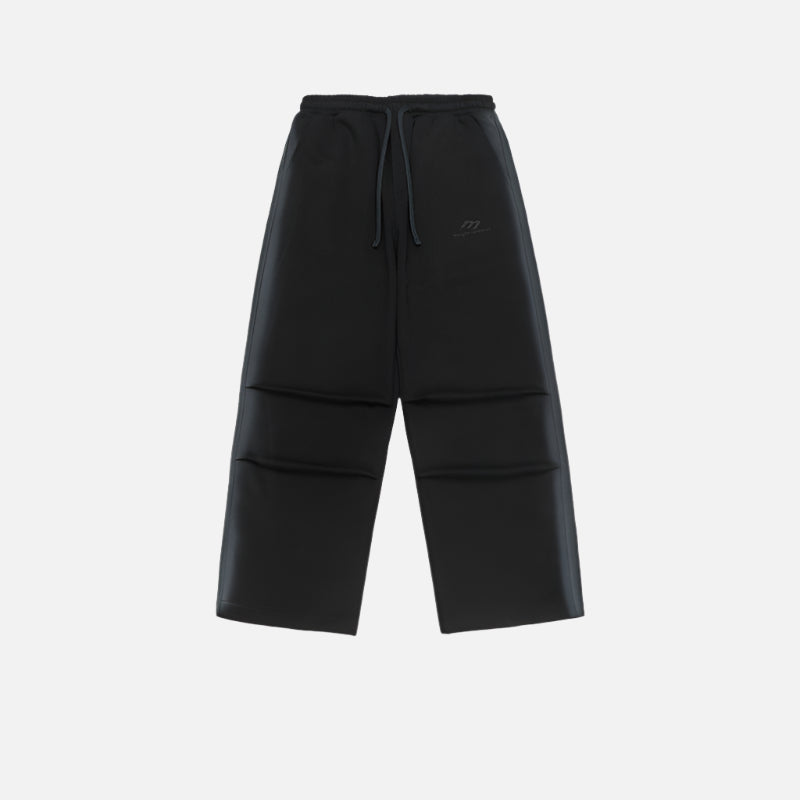 Black wide-leg sweatpants with a minimalist logo, elastic waistband, and drawstrings, displayed flat