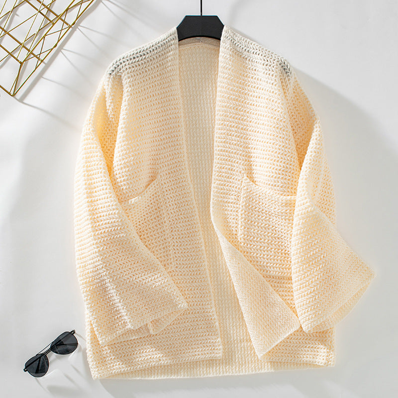 Cream colored oversized cardigan on hanger, featuring same chevron knit pattern and patch pockets
