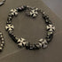 Adjustable bracelet featuring black square beads and silver cross charms for an edgy, modern design.