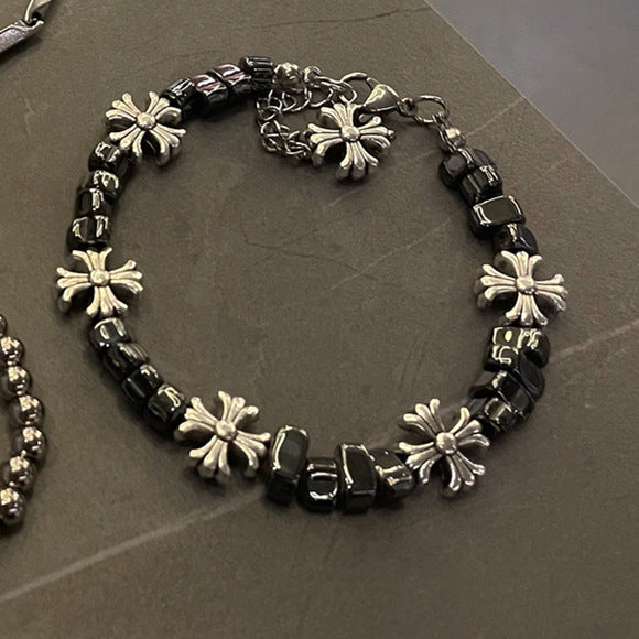 Adjustable bracelet featuring black square beads and silver cross charms for an edgy, modern design.