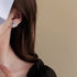 Silver planetary design earring with crystal detailing against dark hair