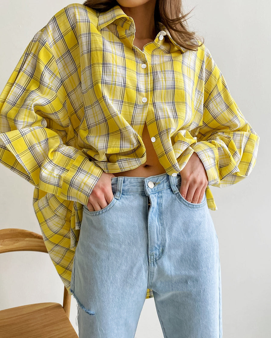 Oversized yellow plaid shirt with cropped styling, paired with light blue denim jeans