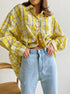 Oversized yellow plaid shirt with cropped styling, paired with light blue denim jeans
