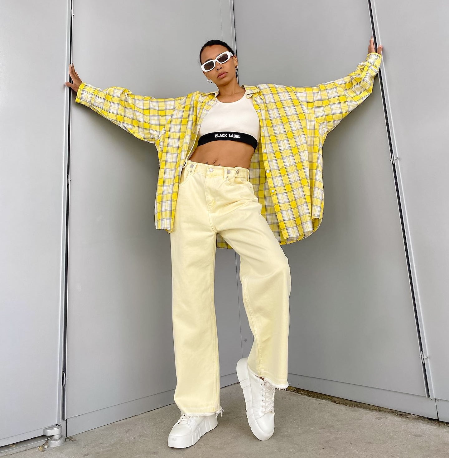 Styled outfit with yellow plaid shirt, white crop top, and light yellow wide-leg jeans