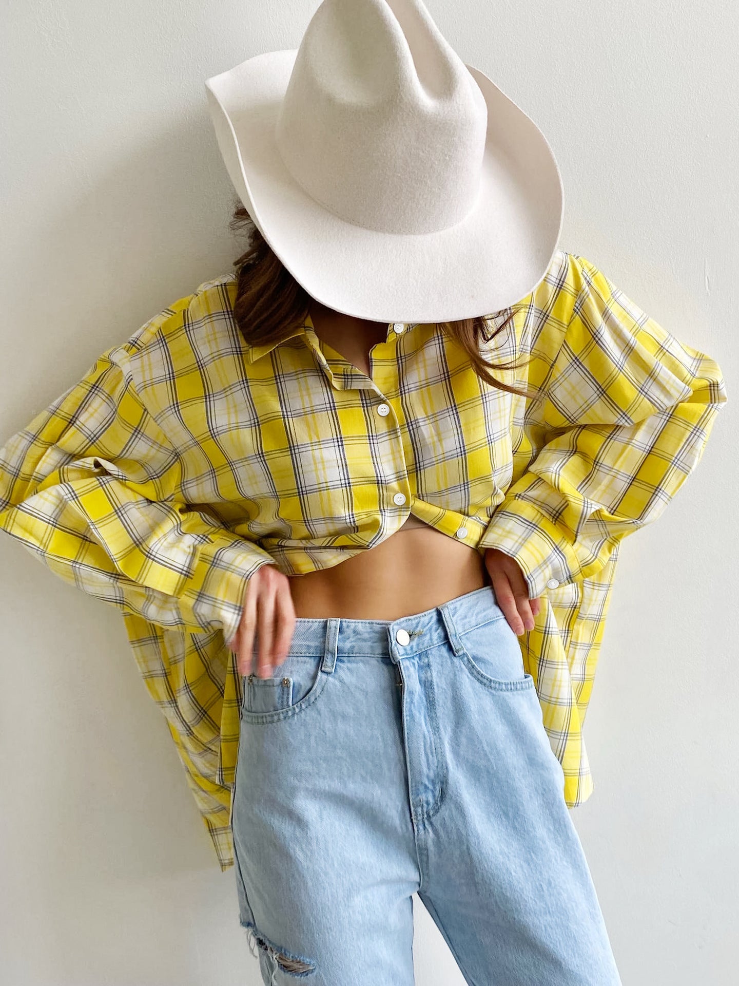 Yellow plaid shirt with white cowboy hat, styled with white crop top and denim