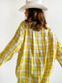 Back view of yellow plaid shirt with white cowboy hat, showcasing relaxed fit