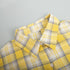 Folded yellow plaid shirt highlighting check pattern and fabric texture