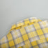 Yellow plaid shirt fabric with intricate weave and button details