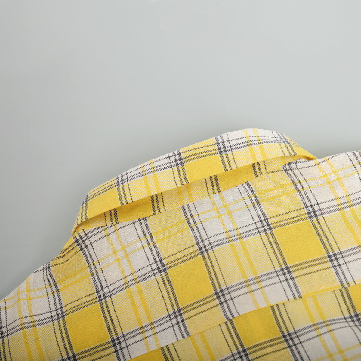 Yellow plaid shirt fabric with intricate weave and button details