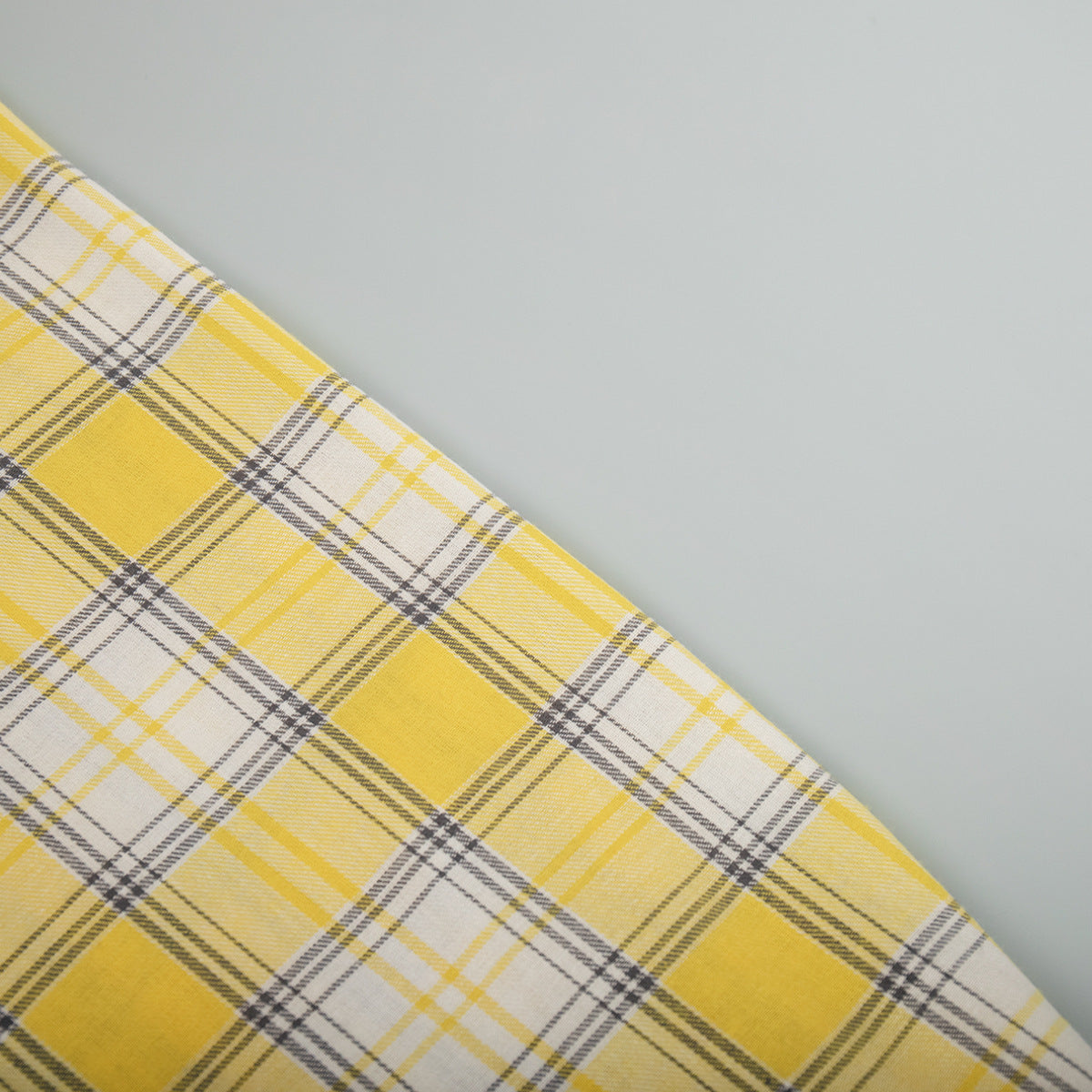 Layered view of yellow plaid shirt fabric showing pattern and folds