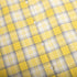Curved edge of yellow plaid shirt with distinct check design