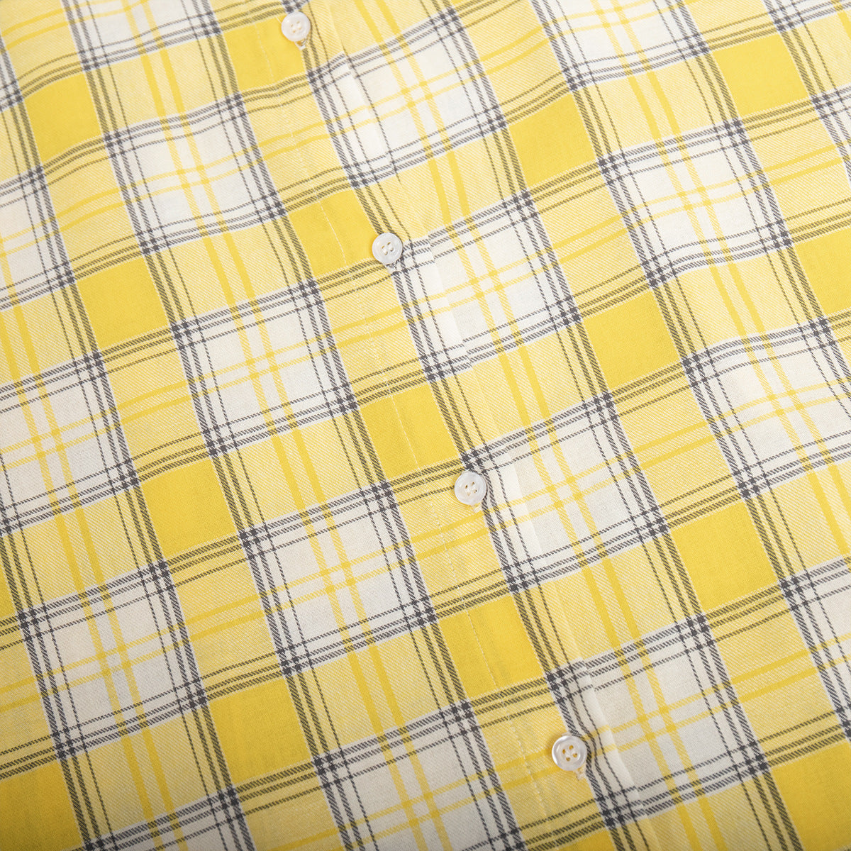 Curved edge of yellow plaid shirt with distinct check design