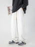 A model wearing oversized black sweatshirt and wide-leg heather gray sweatpants with drawstring waist, standing against light background