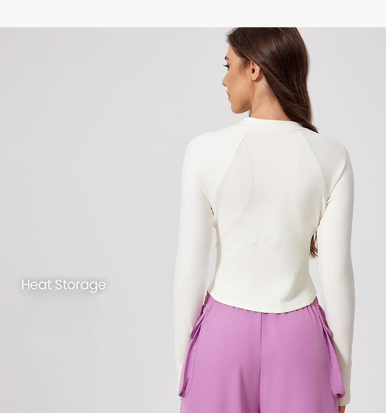 A model is shown from behind wearing a white fitted crop top with raglan sleeves and lilac joggers. Heat Storage text visible in corner
