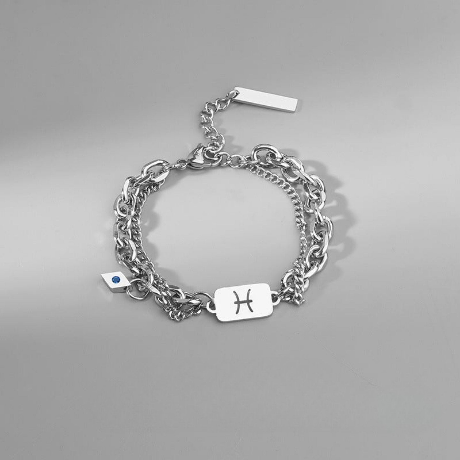 Pisces zodiac bracelet in silver-tone stainless steel, featuring a layered chain design and an engraved charm.