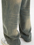 Close-up of olive-green wide-leg jeans showing faded wash pattern, distinctive vertical seams, and relaxed fit with gray sneakers visible at bottom
