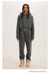 Charcoal Grey Sweatshirt and Joggers Set – Model in a dark grey hoodie and joggers, paired with beige sneakers