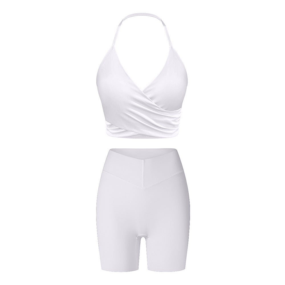 Pure white workout set featuring wrap-style halter sports bra and high-waisted compression shorts with v-shaped panel