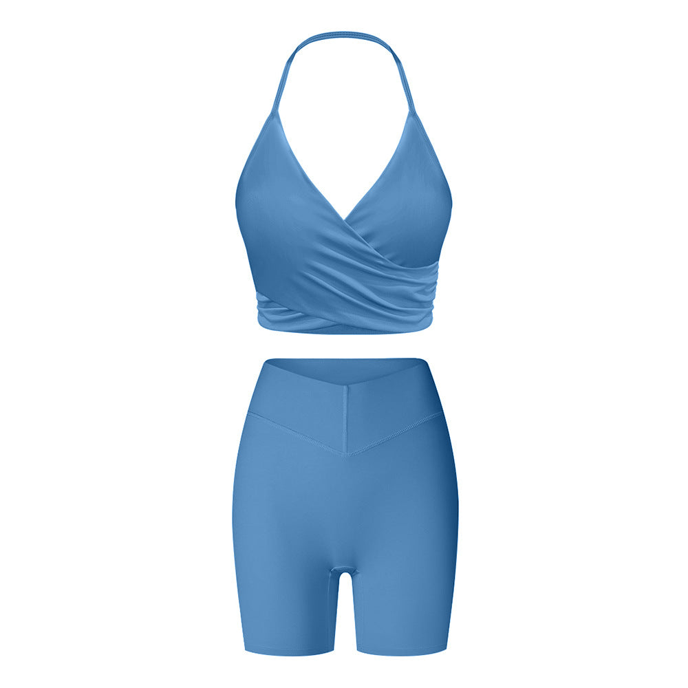 Blue workout set with halter sports bra and biker shorts, featuring seamless fabric and high-waist design